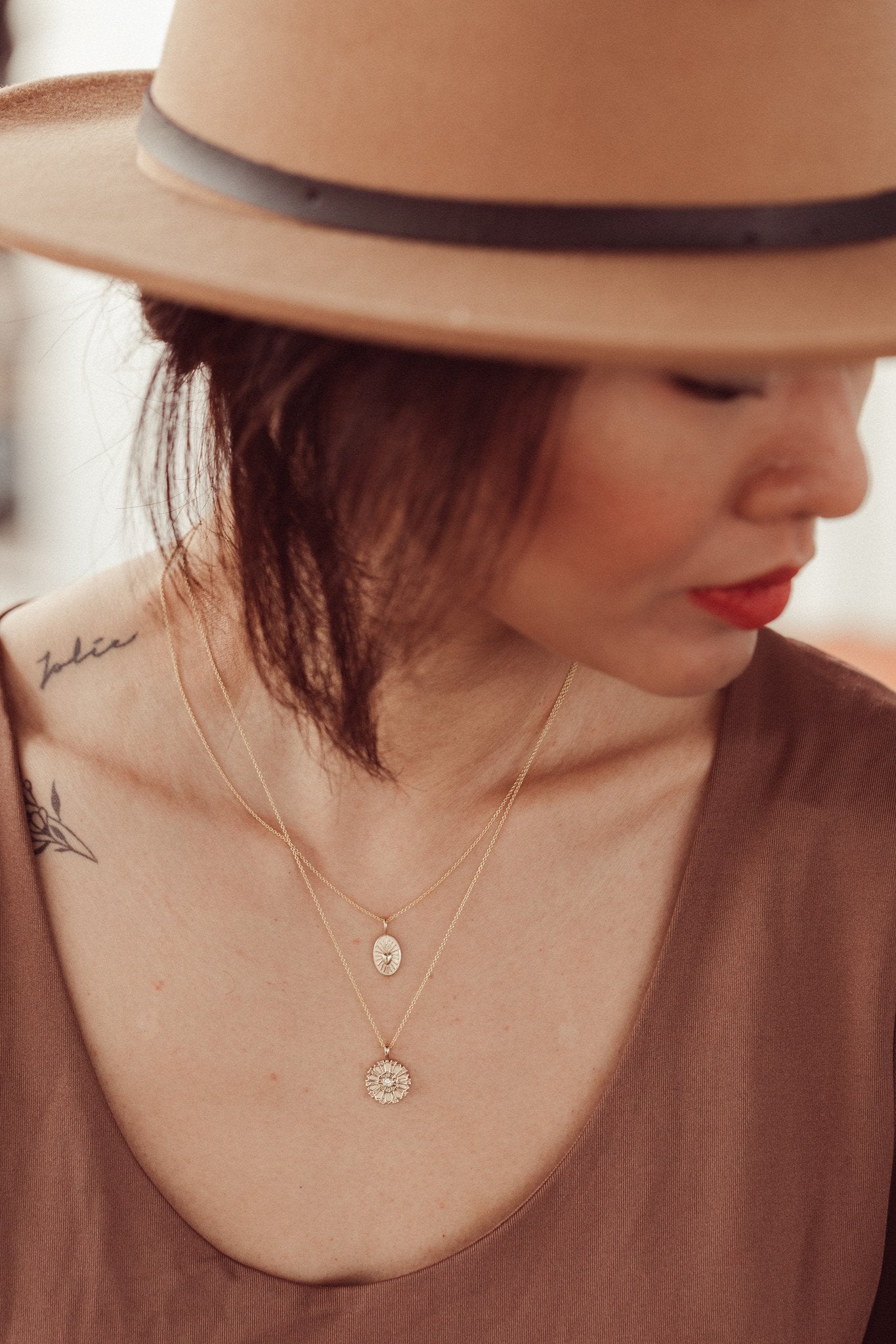 Gold necklace with a heart charm on a models neck