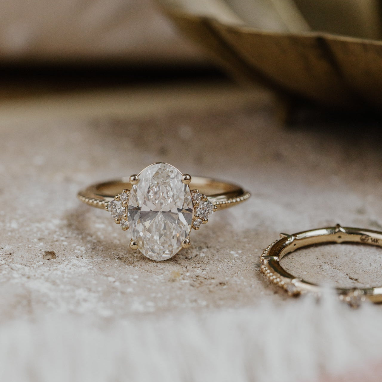 Gold ring with a large oval  diamond on a textured surface