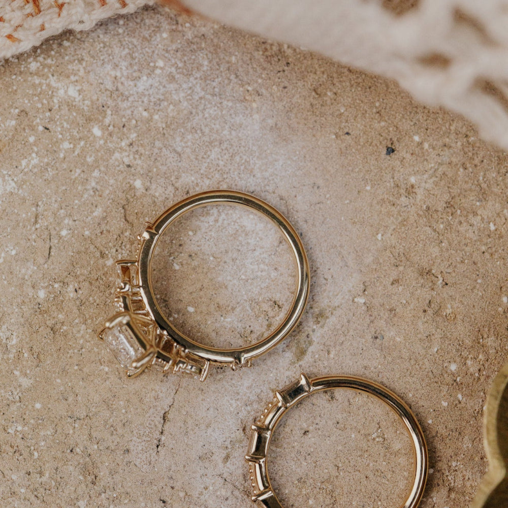 Gold diamond ring on a textured beige surface