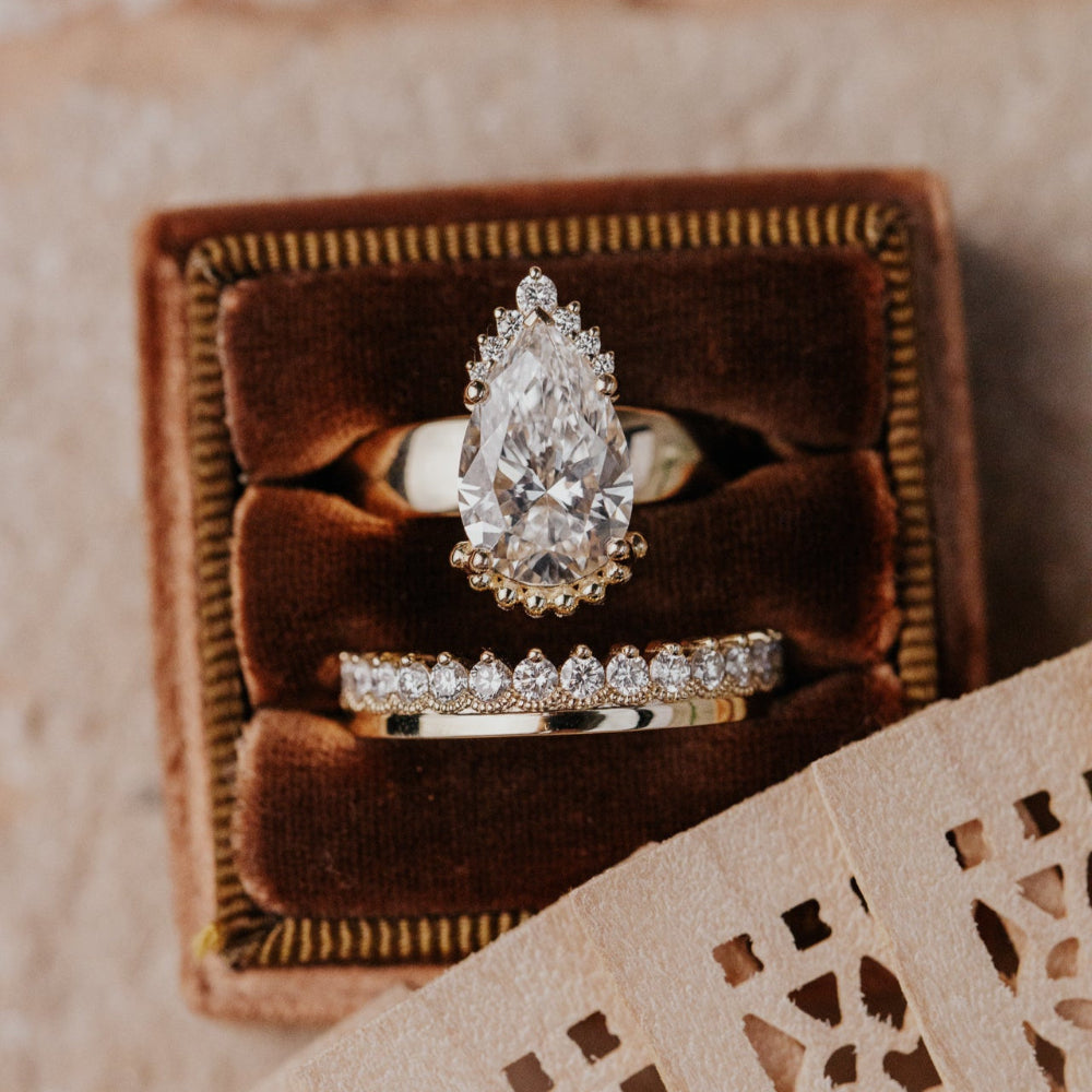 pear shaped Diamond ring in a brown velvet box with a textured surface