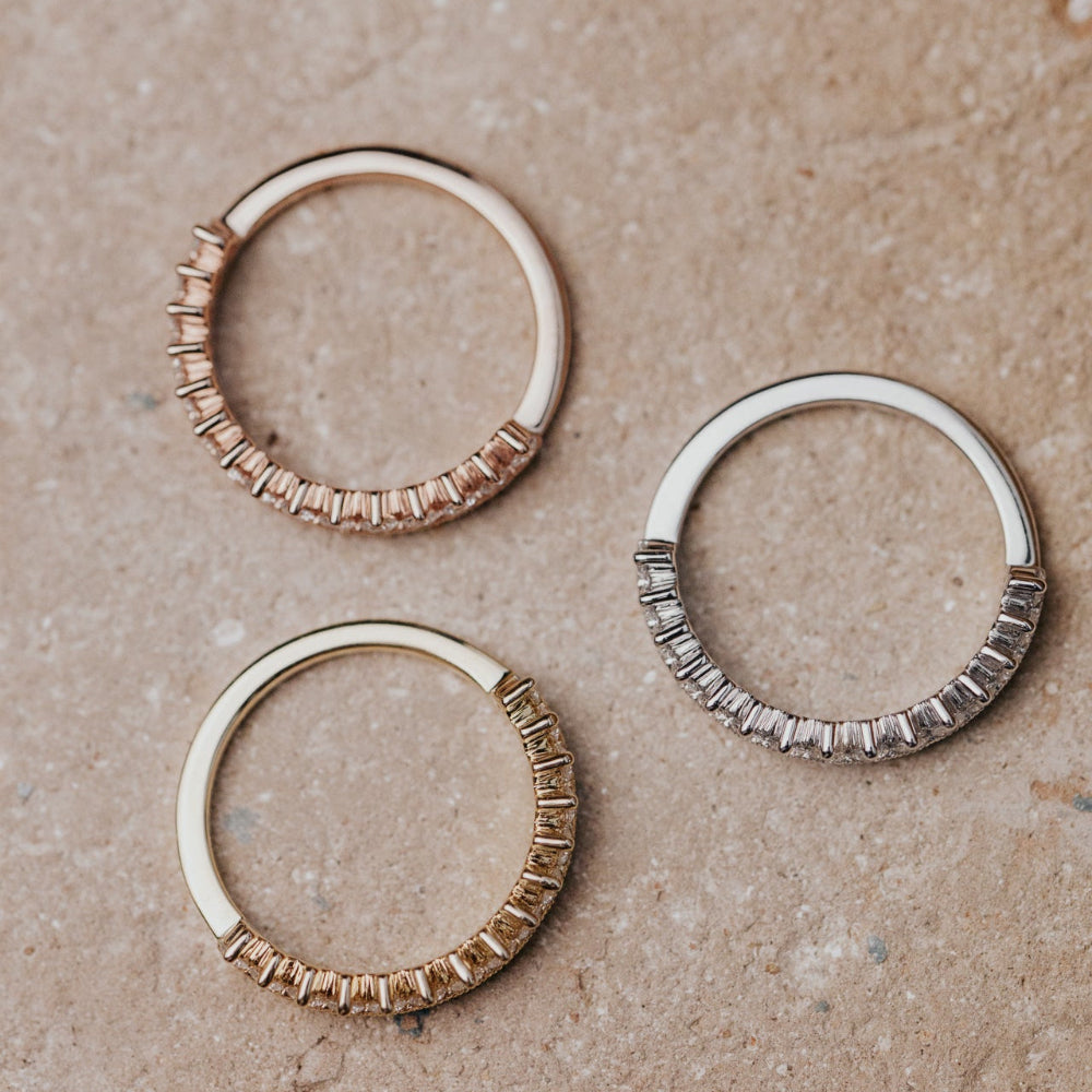 Three gold ringsn a textured beige surface