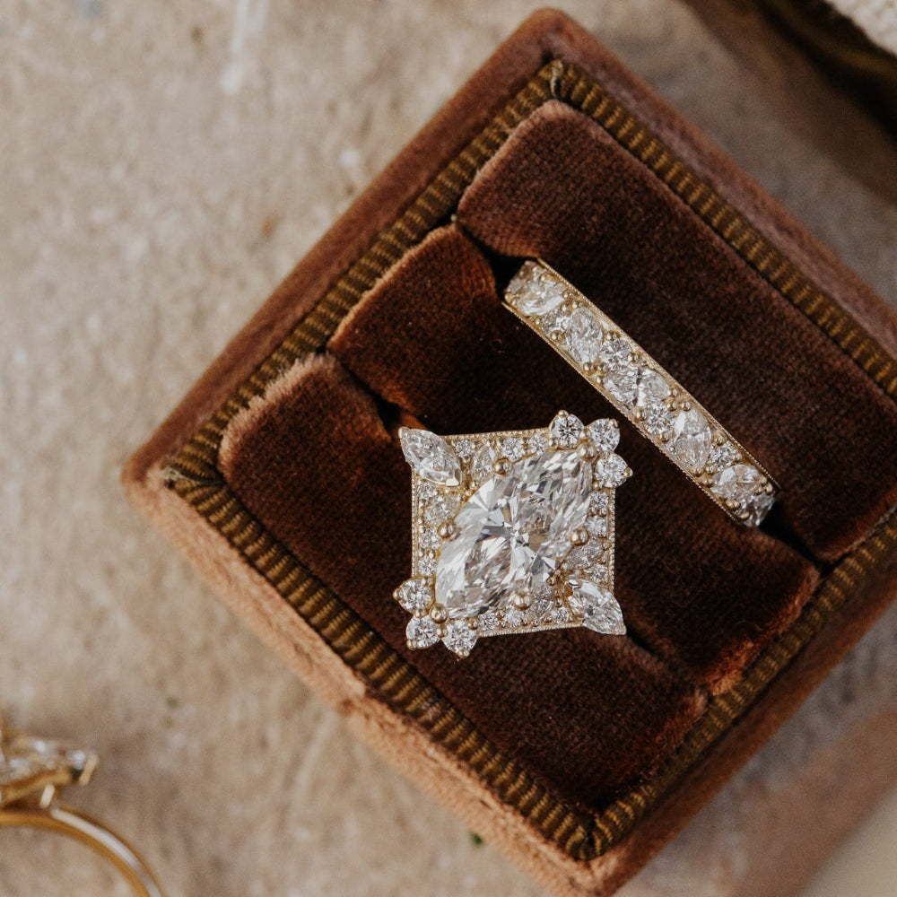 Two diamond rings on a brown velvet cushion with a textured surface.