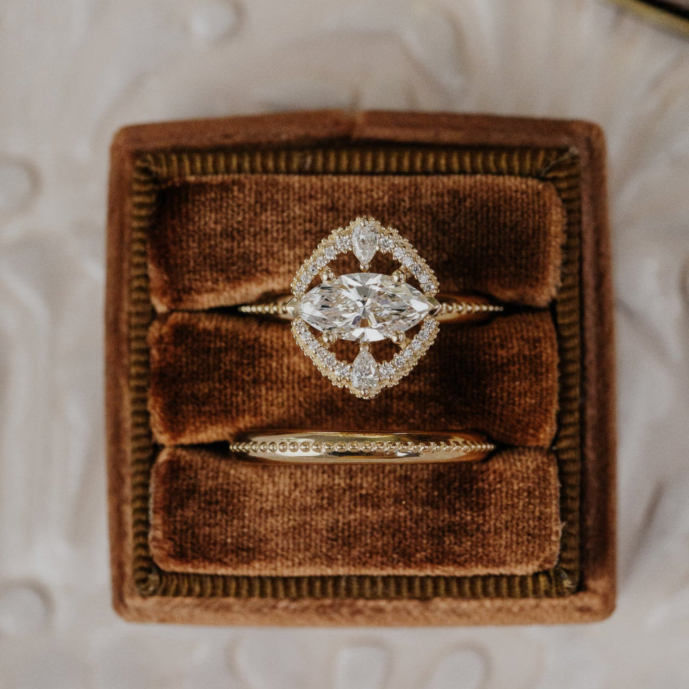 Diamond ring in a brown velvet box on a textured surface