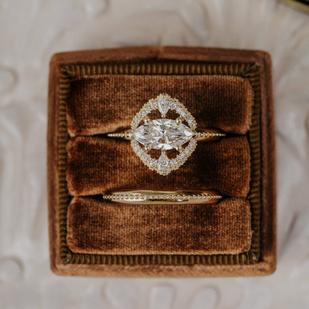 Diamond ring in a brown velvet box on a textured surface
