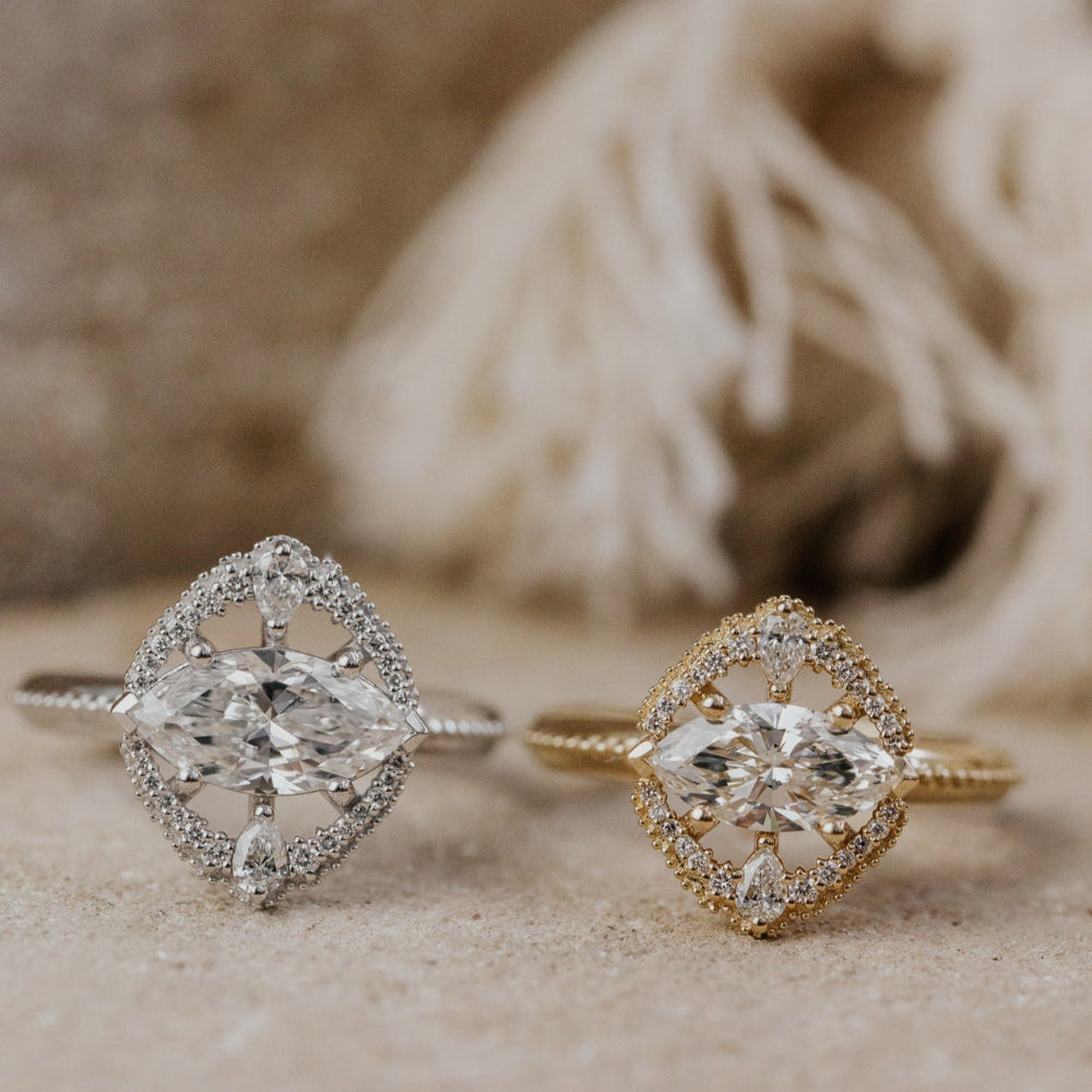 Two diamond rings, one white gold and one yellow gold, on a textured surface.