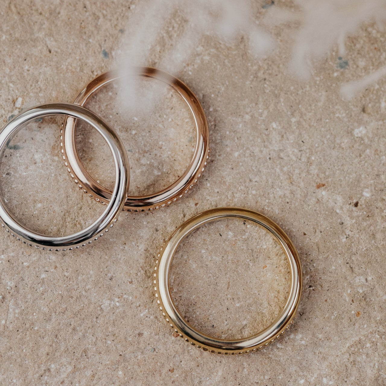 Three gold rings on a textured surface