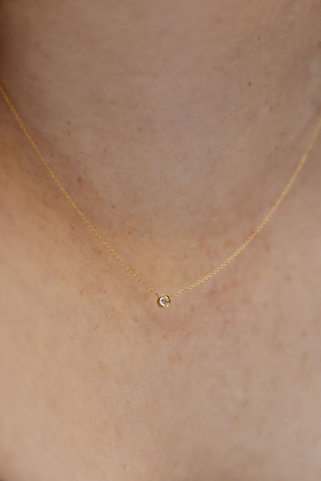 Bezel Set Diamond on Chain Necklace on a 14k yellow gold chain on a models neck