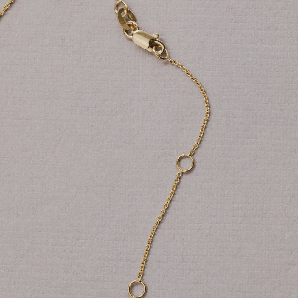 Gold chain necklace on a gray background