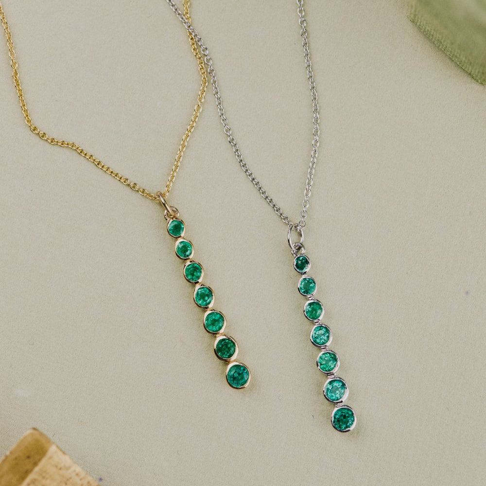 Two emerald necklaces on a light background