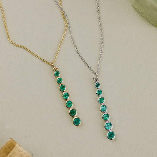Two emerald necklaces on a light background