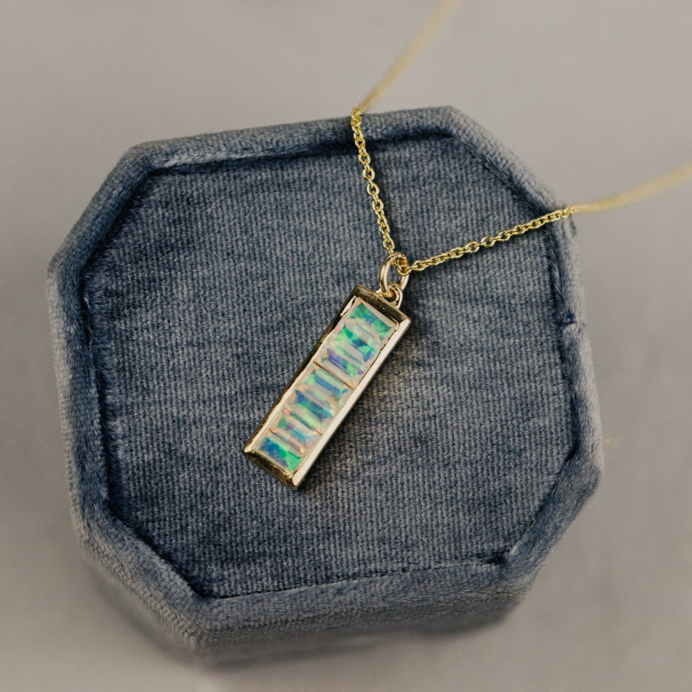 Necklace with a Opal pendant on a gray textured surface