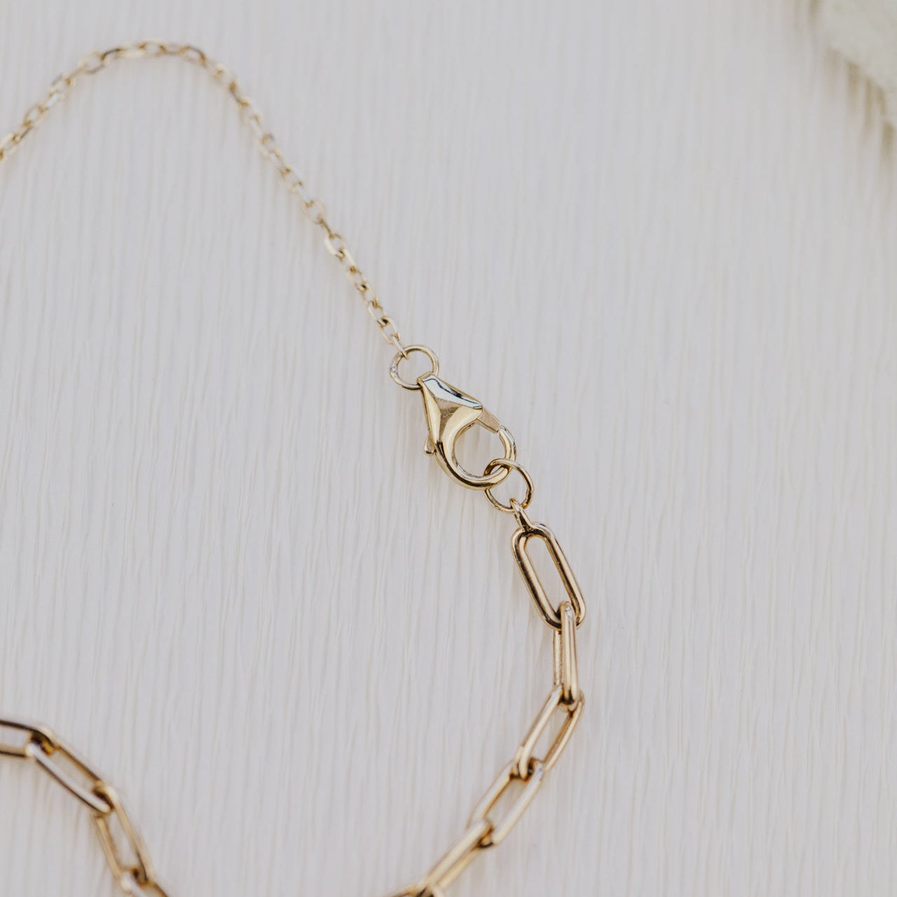 Gold chain necklace on a light background