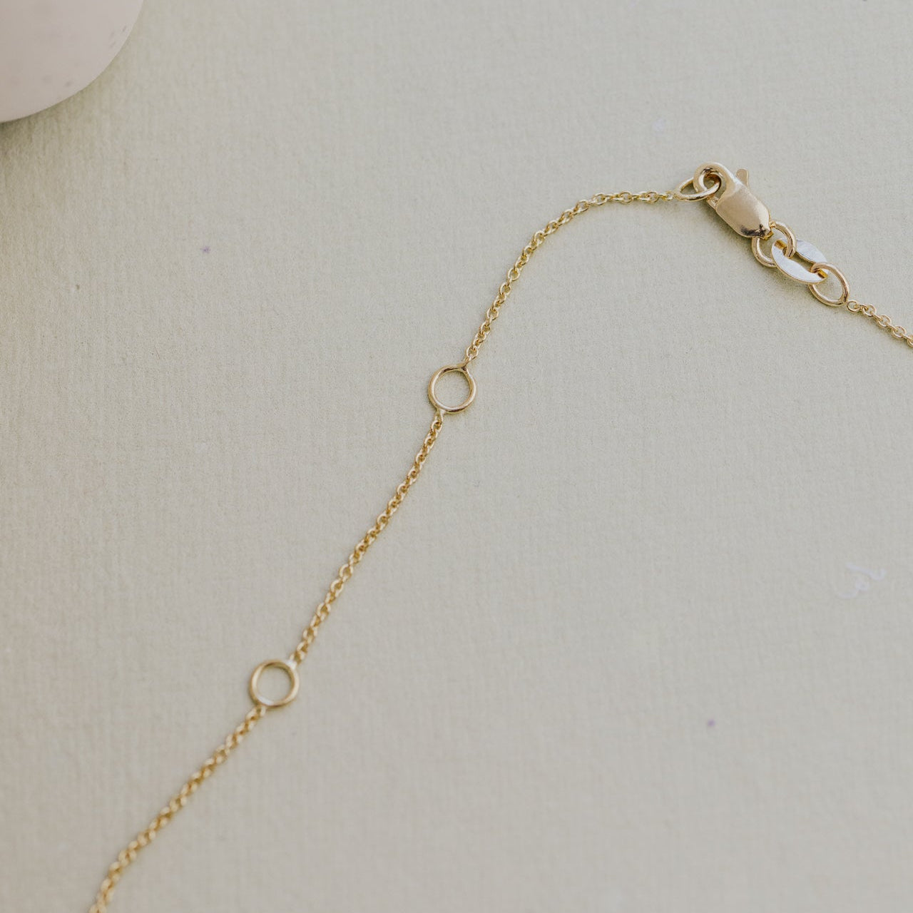 Gold chain bracelet on a light gray background