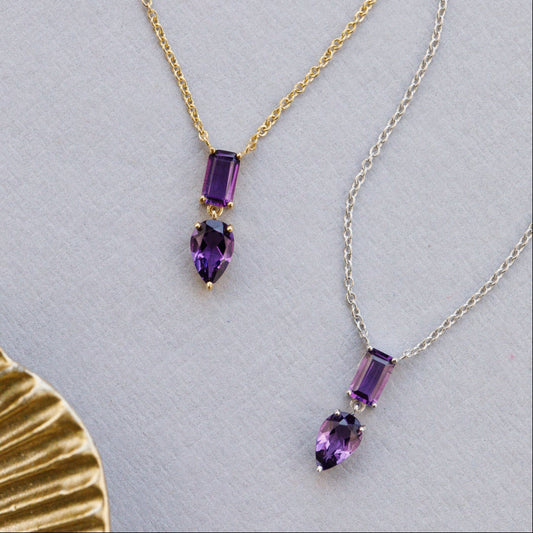Two necklaces with purple amethyst gemstones on a light gray background