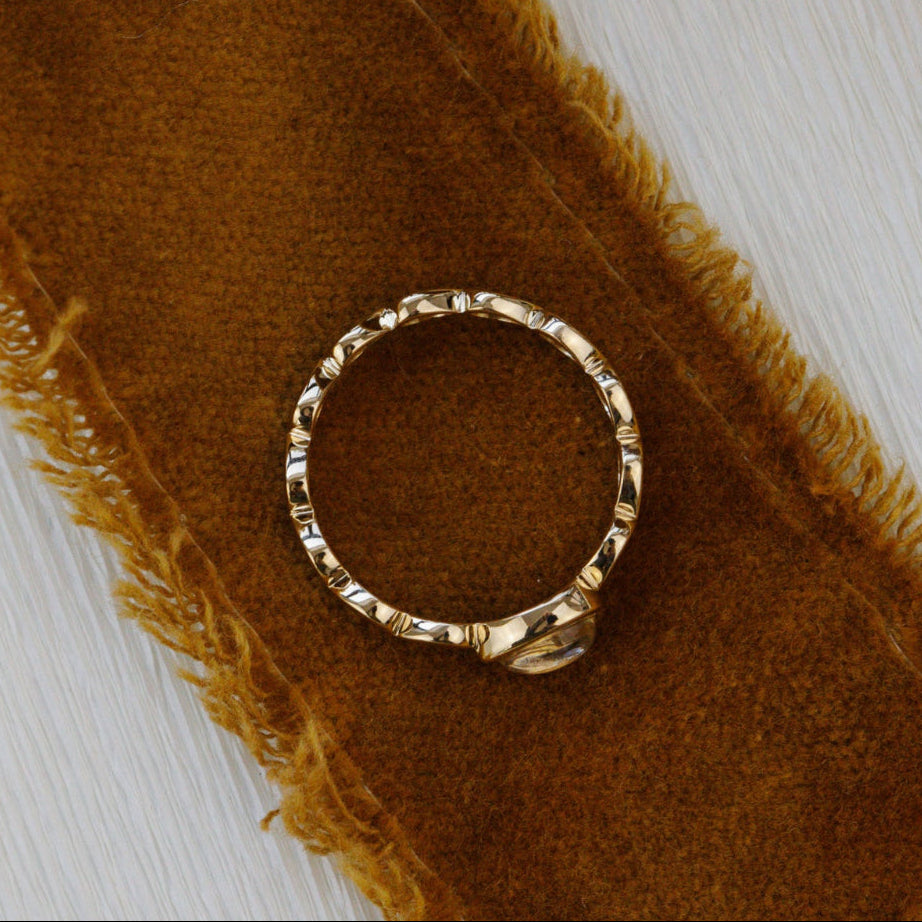 Gold ring on a brown textured fabric background