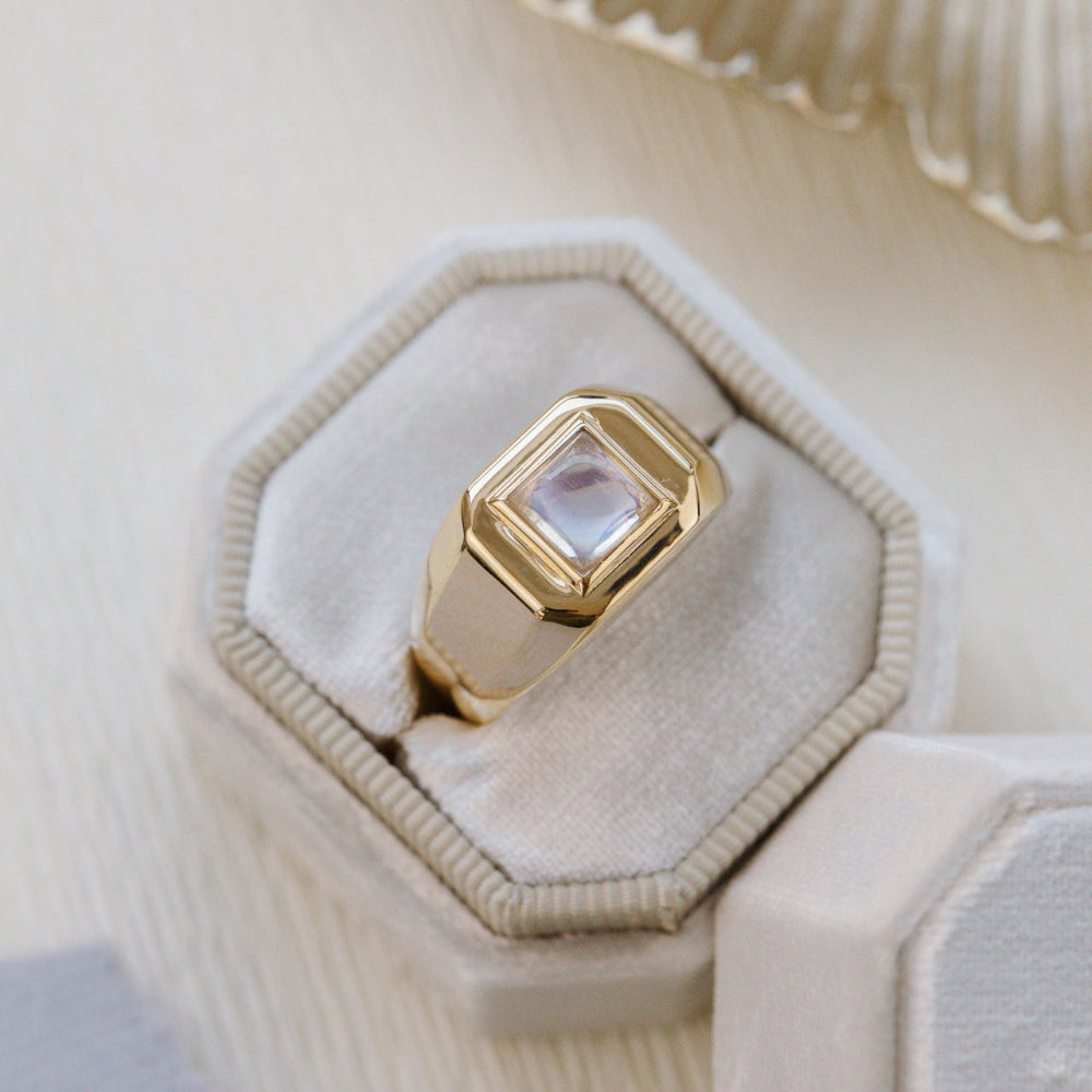 Gold ring with a pink stone in a decorative box