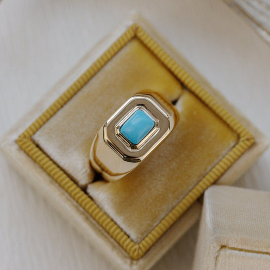 Gold ring with a turquoise stone on a yellow cushion