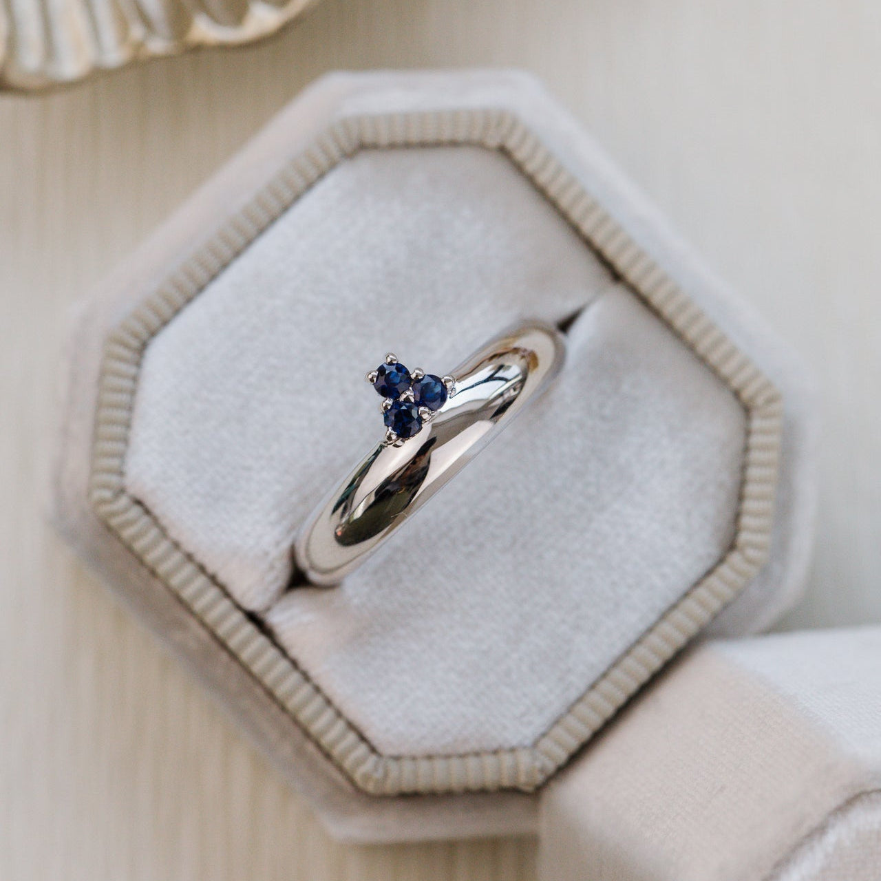 Gold ring with blue stones in a hexagonal jewelry box