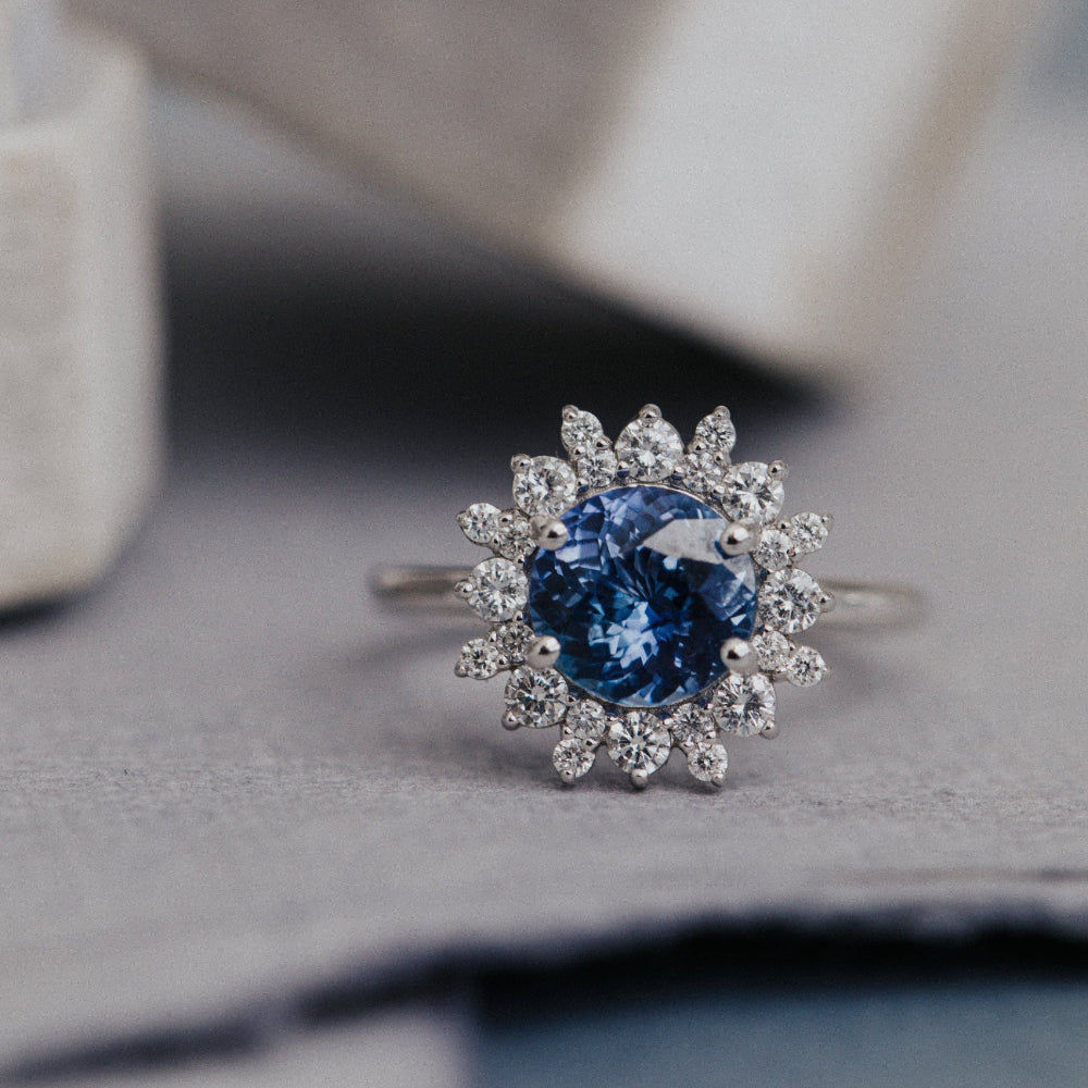 Silver ring with a blue sapphire gemstone on a textured surface