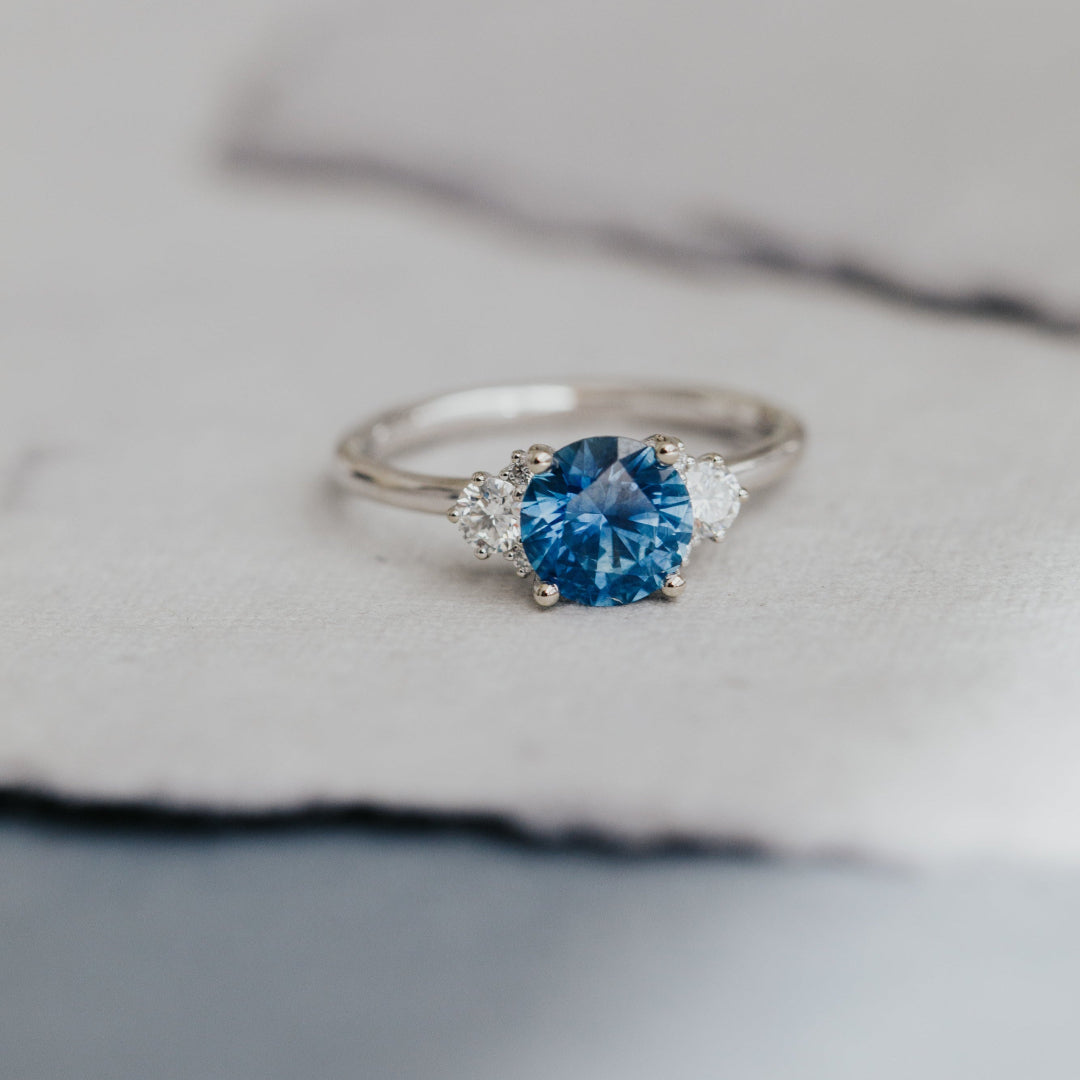 Silver ring with a blue Montana Sapphire on a soft fabric background