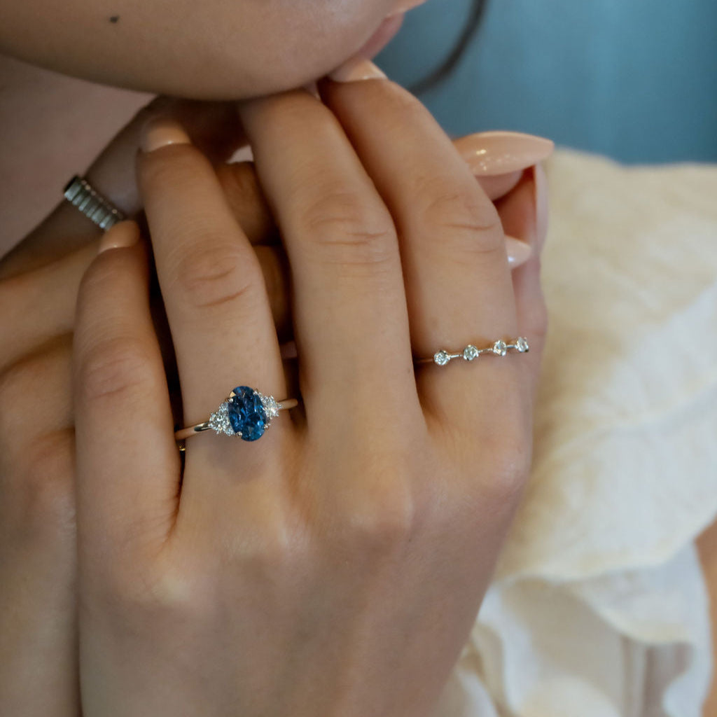 Close-up of a hand  model wearing a ring with a  blie sapphire