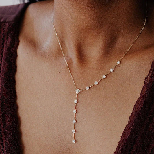 diamond lariat necklace worn by a person with a blurred background