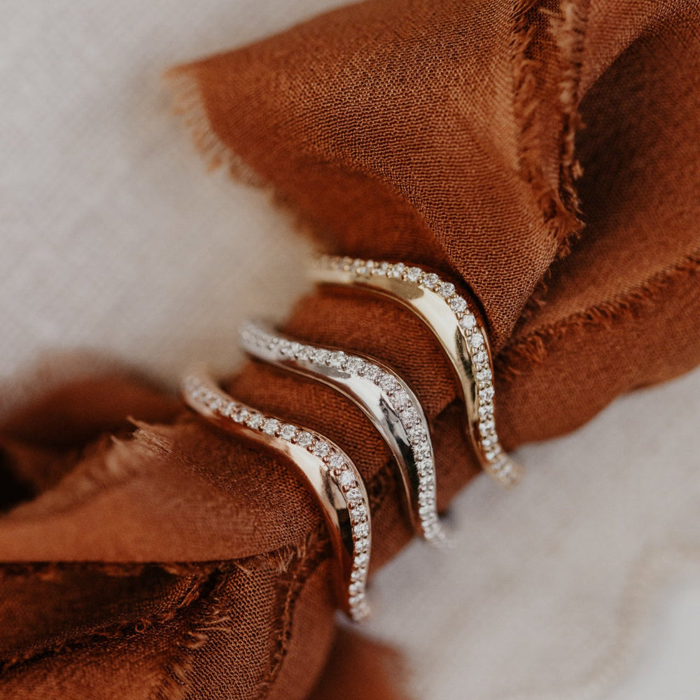 Three diamond wedding band  on a brown fabric surface