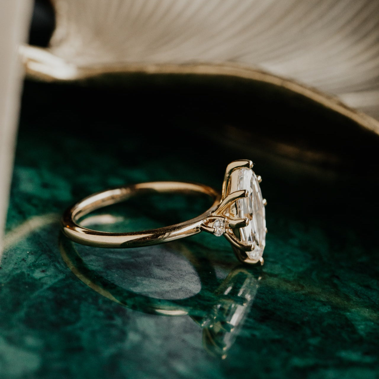 Gold ring with a large diamond on a green surface