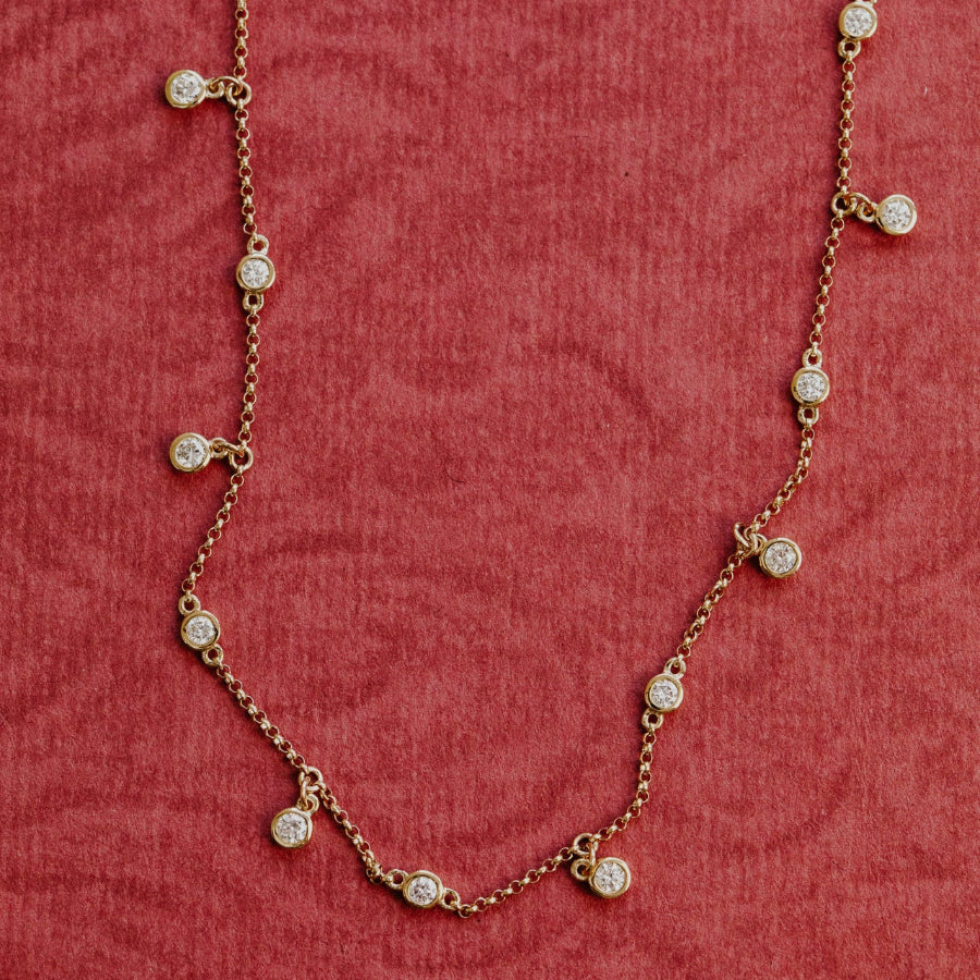 Gold necklace with diamond stones on a red textured background