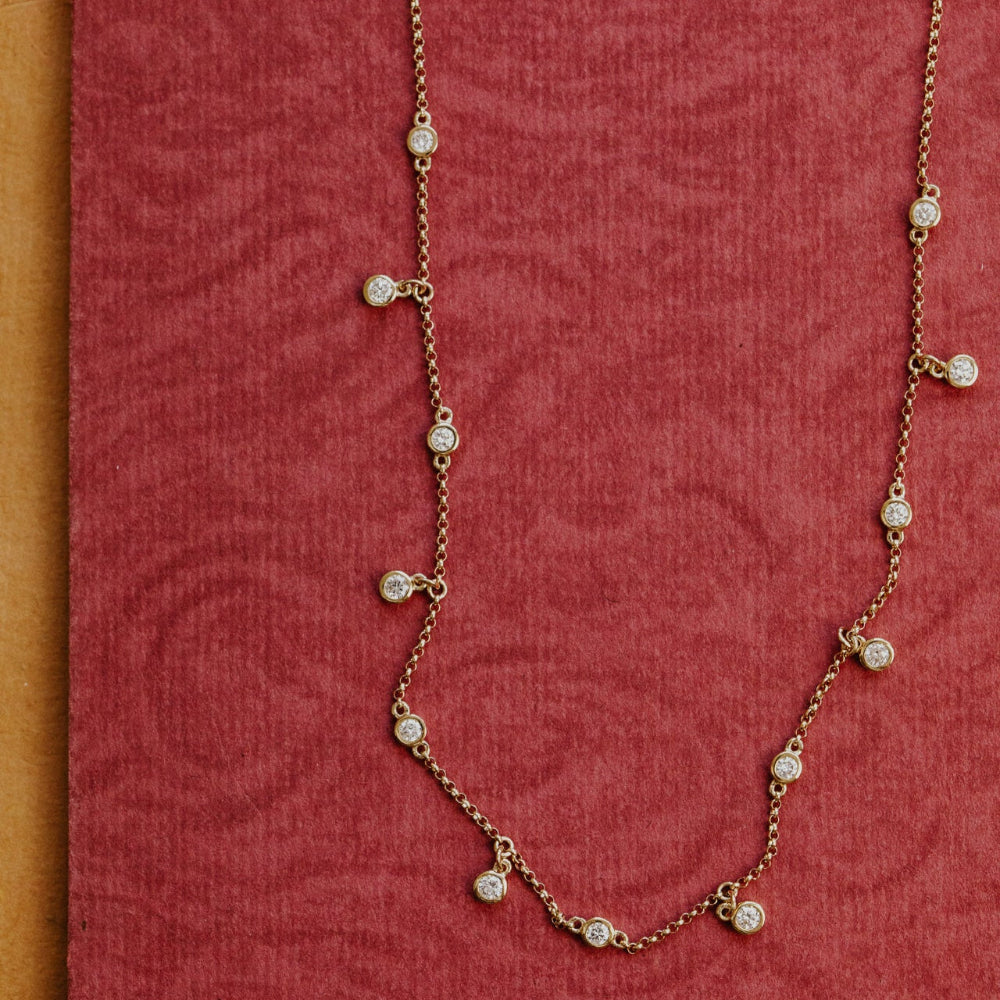 Gold necklace with diamonds on a red fabric background