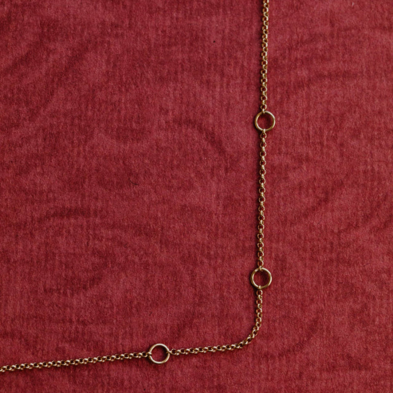 Gold chain on a red textured fabric background