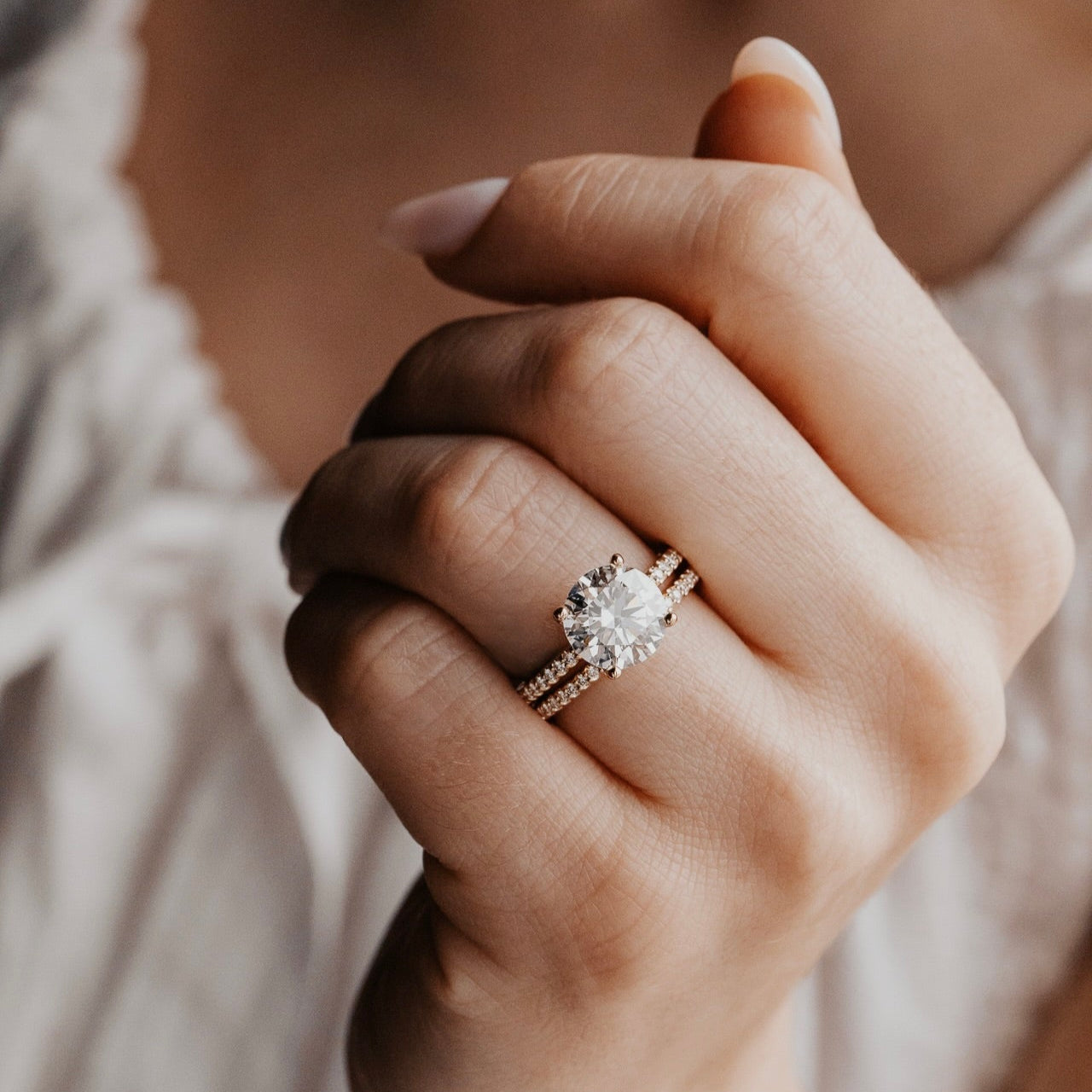 The Jenna Round Diamond Engagement Ring on a pave diamond band