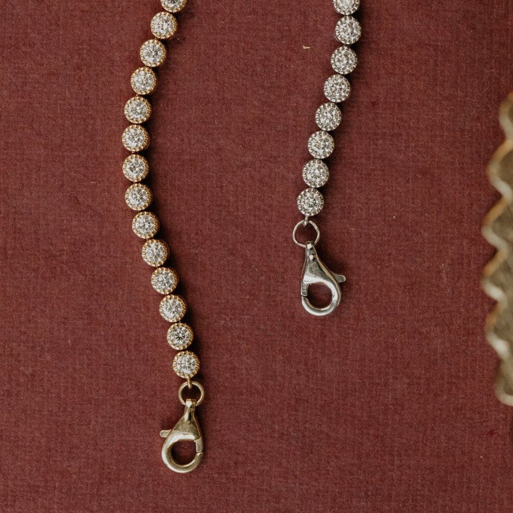 gold tennis bracelets with clasp on a red background