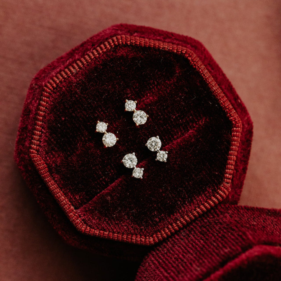 Red velvet box with diamond earrings on a brown background