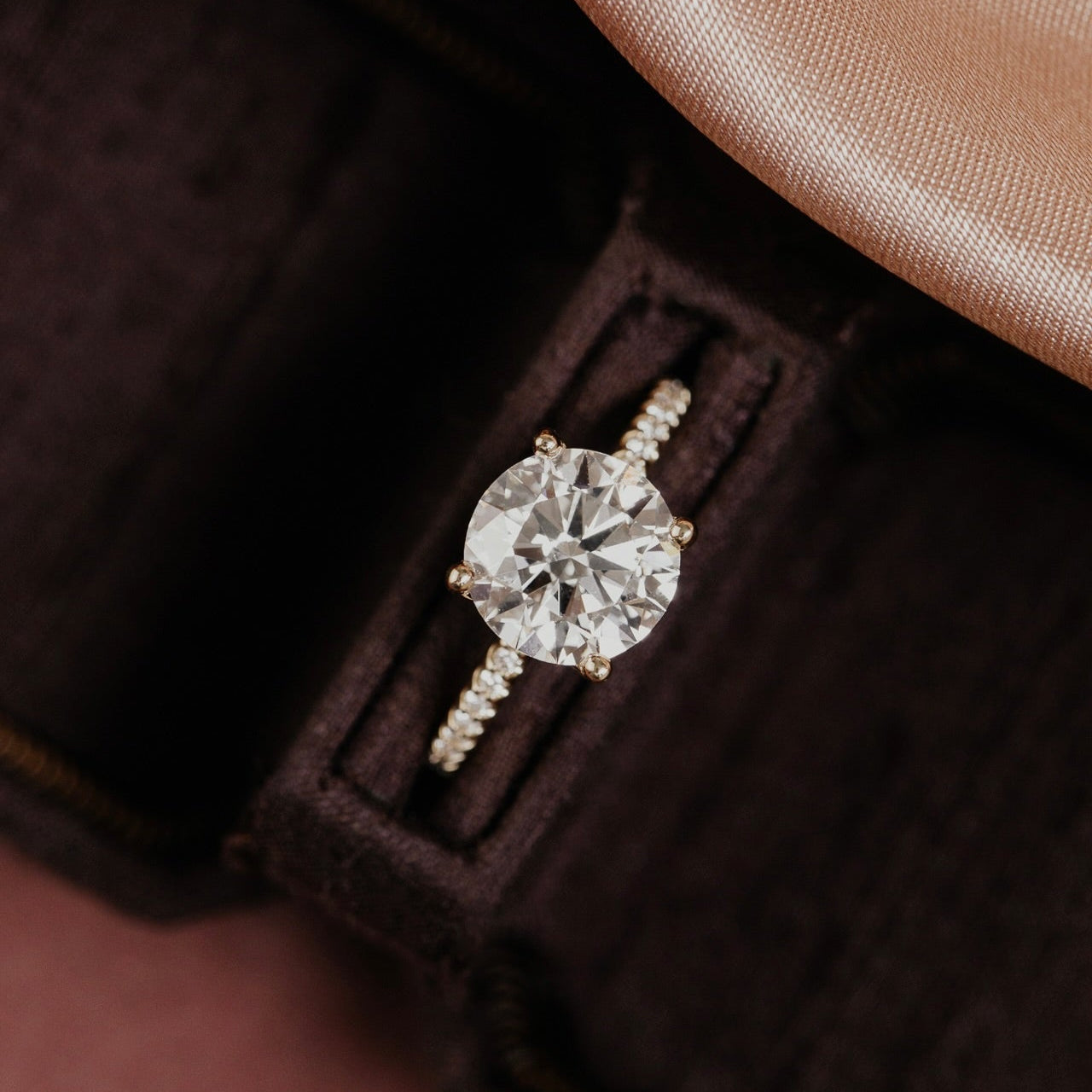 The Jenna Round Diamond Engagement Ring on a pave diamond band