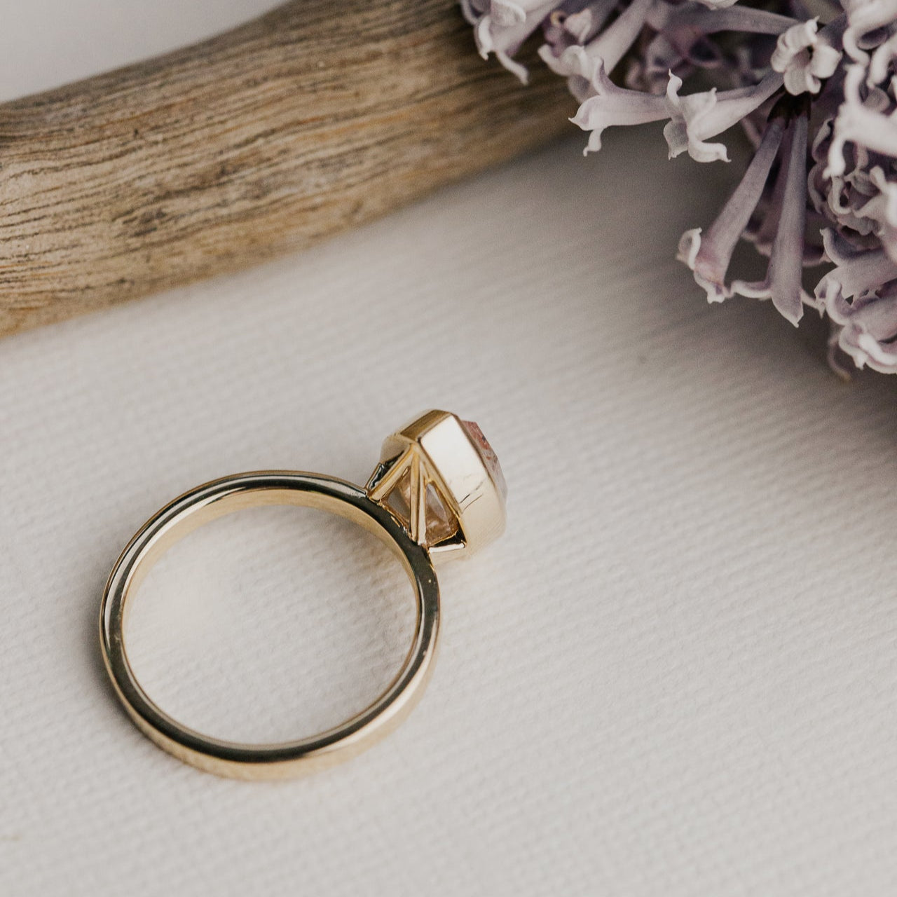 14k gold ring featuring a clear pear rustic rose cut diamond set in a bezel design.