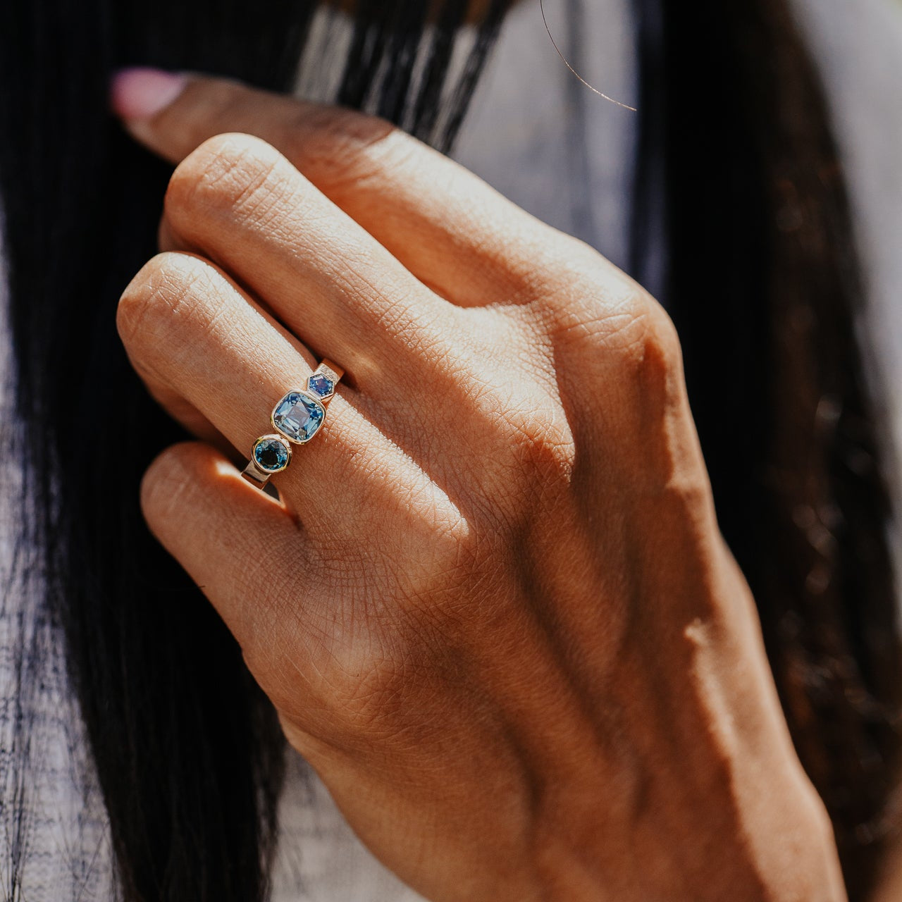 Close-up of a hand wearing a cushion blue Australian sapphire ring