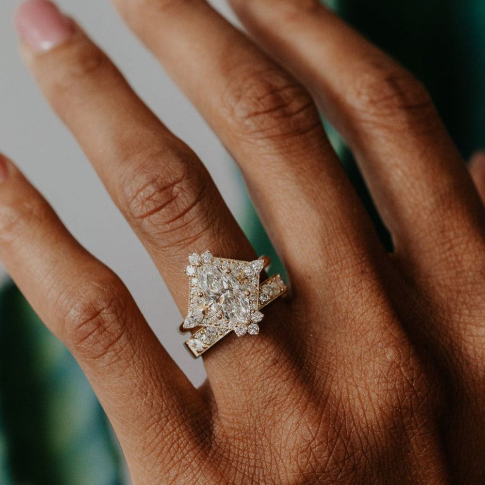 Hand wearing a diamond band with a blurred green plant background