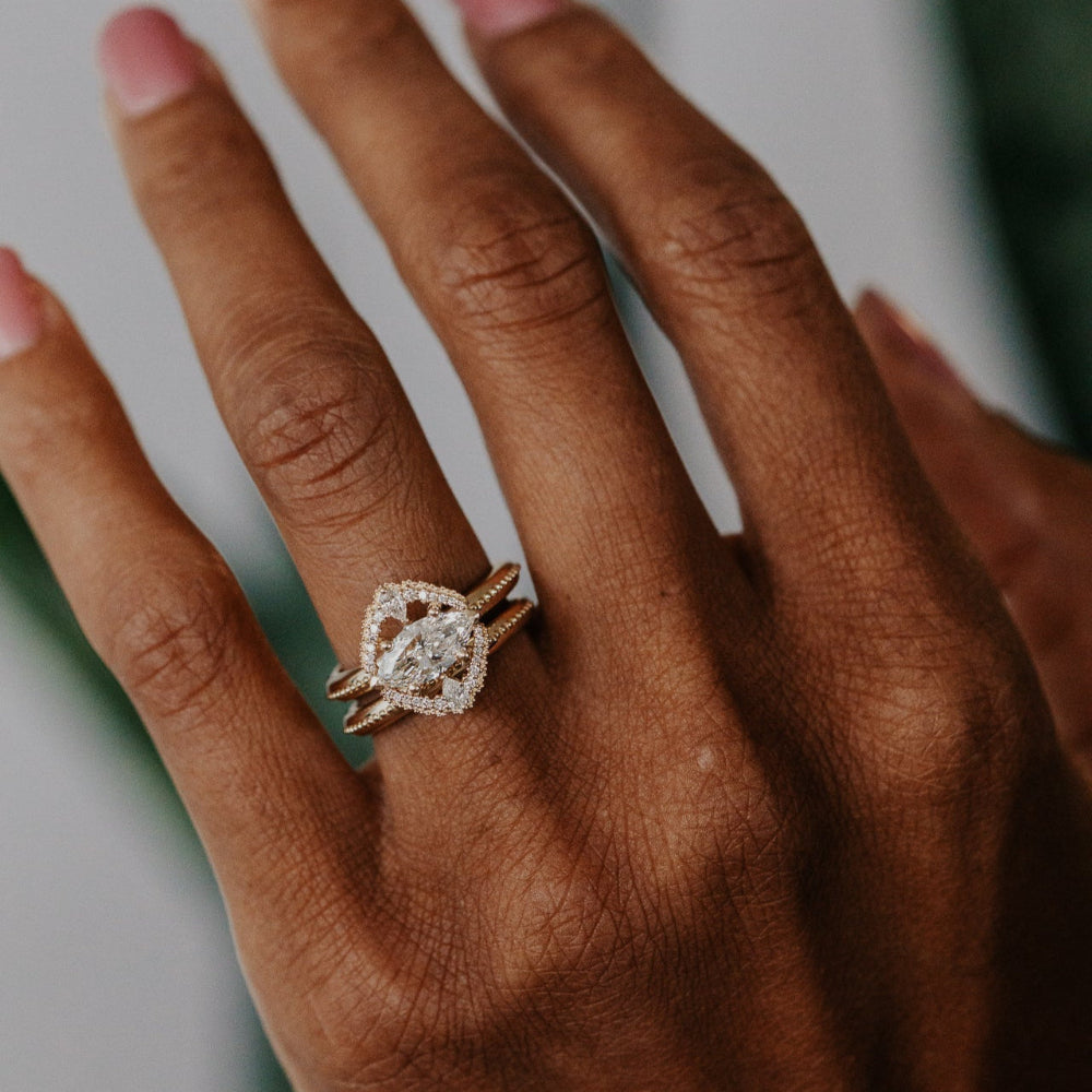 Hand wearing a diamond ring with a blurred background