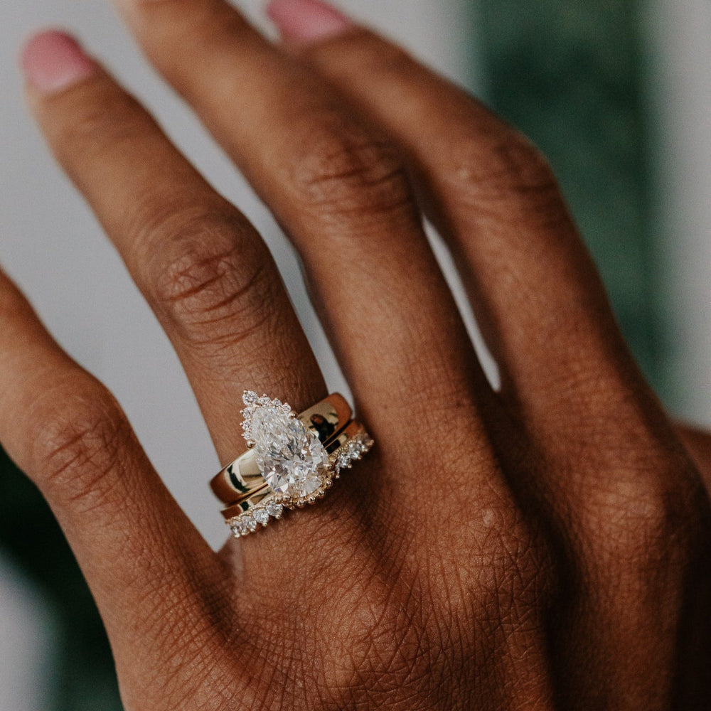 Close-up of a hand wearing a diamond ring with a blurred background