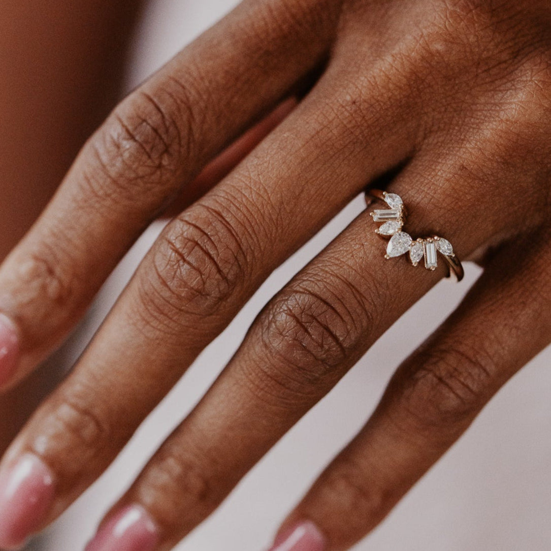 14k gold wedding band featuring pear, marquise, and baguette diamonds set in prongs in a starburst design.