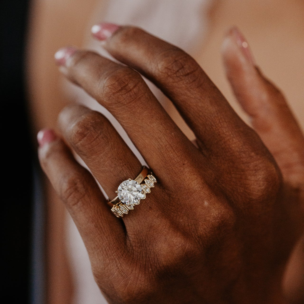 14k gold wedding band featuring round diamonds set in an elongated hexagon pattern paired with a round diamond solitaire ring