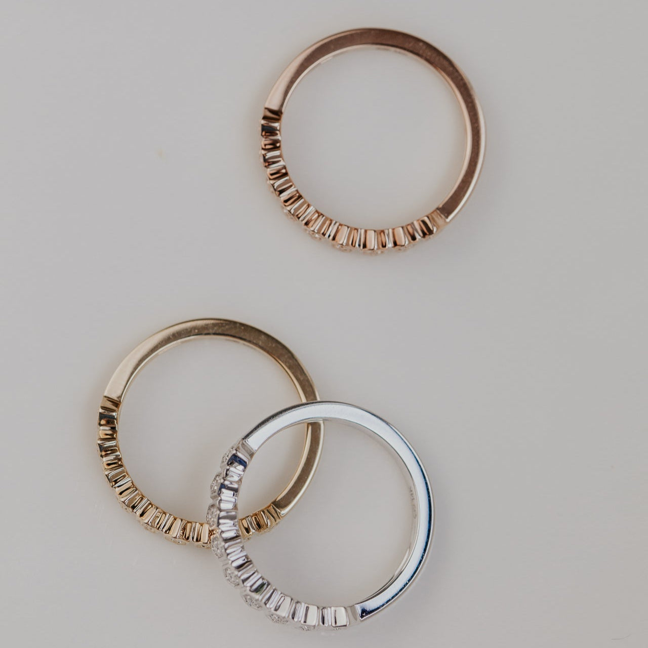 14k gold wedding band featuring round diamonds set in an elongated hexagon pattern.