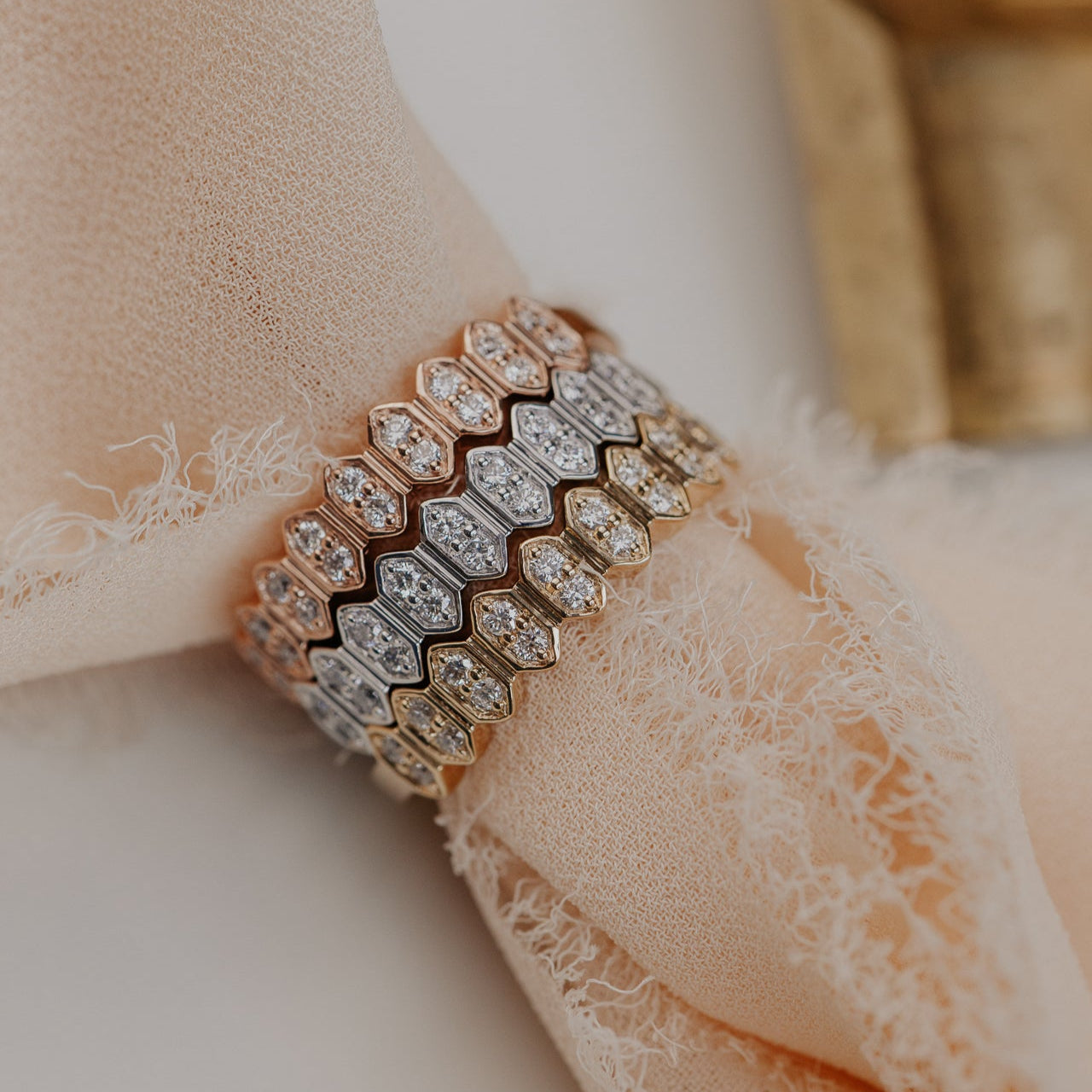 14k gold wedding band featuring round diamonds set in an elongated hexagon pattern.