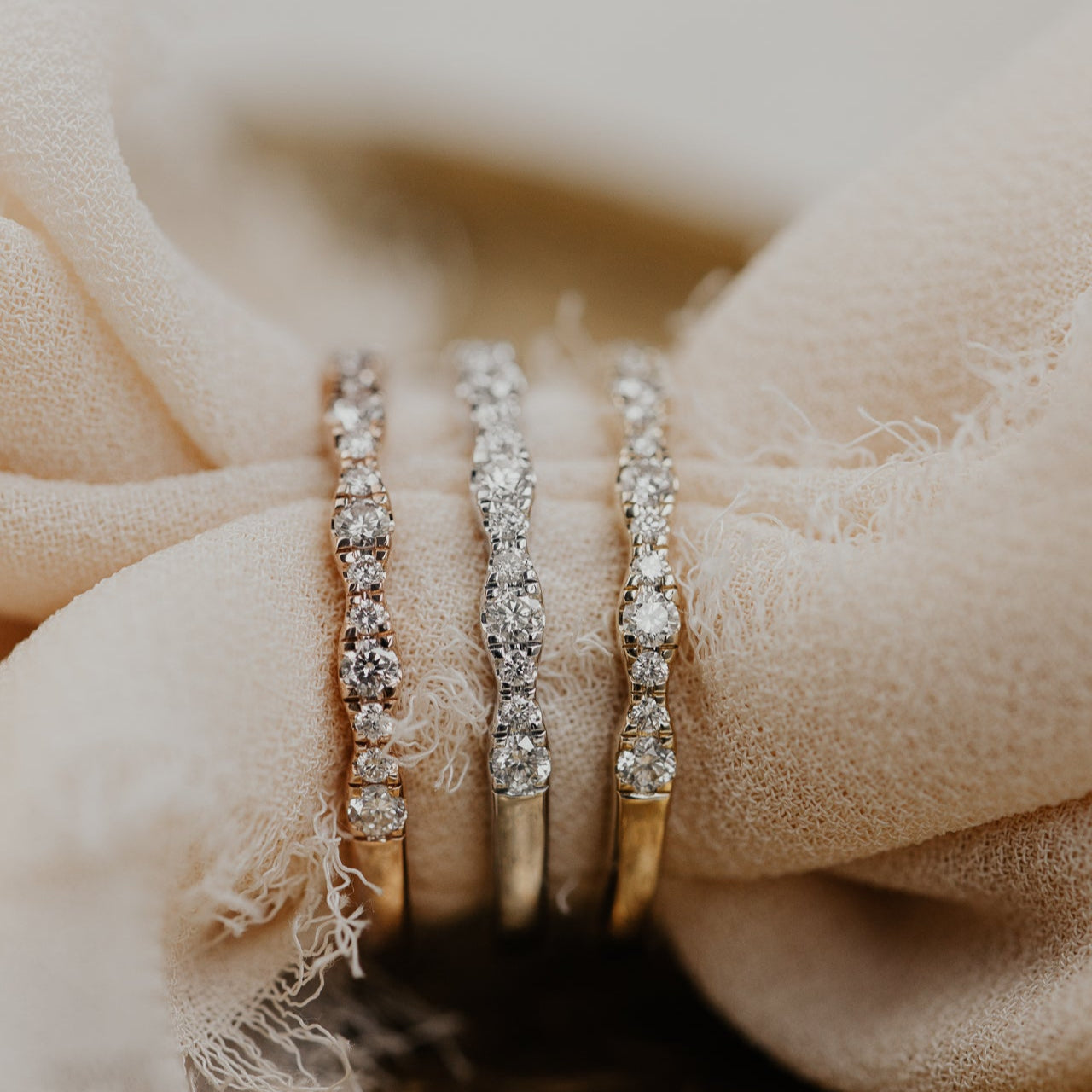 14k gold band  featuring ~.29 cttw pave round diamonds in a wave pattern