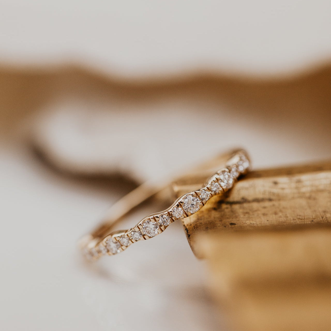 14k gold band  featuring ~.29 cttw pave round diamonds in a wave pattern