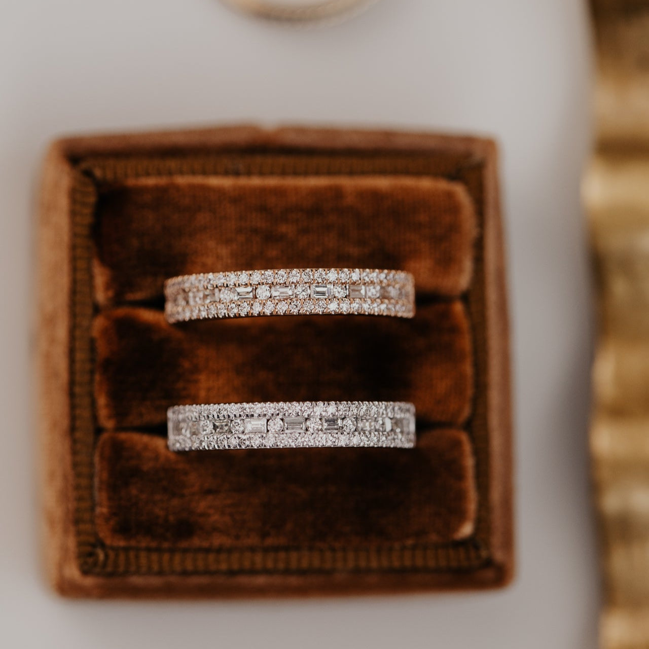 14k gold wedding band with alternating horizontal baguette and round diamonds set between two rows of round pave diamonds.