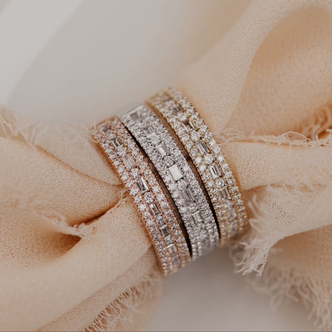 14k gold wedding band with alternating horizontal baguette and round diamonds set between two rows of round pave diamonds.