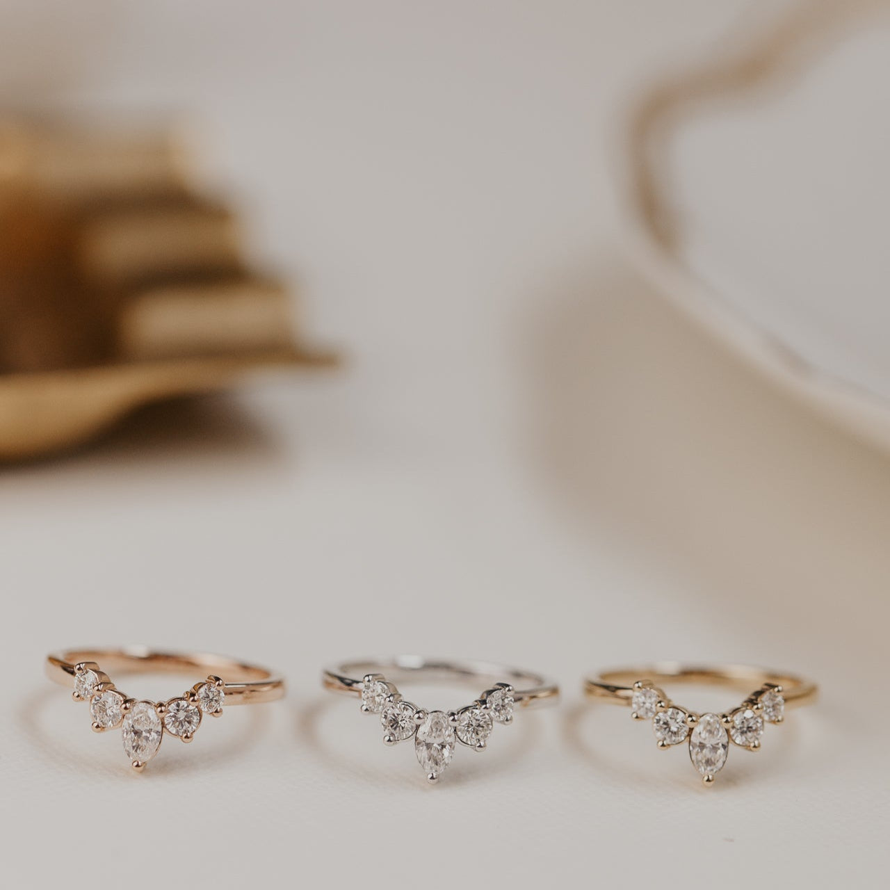 14k gold wedding band with round and oval diamonds, set in prongs in a starburst design.