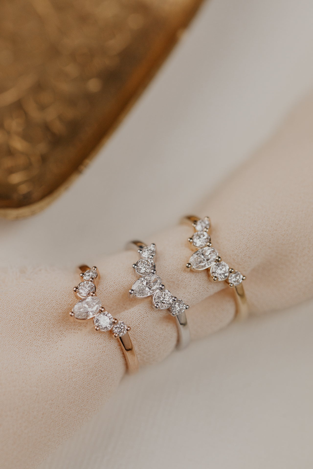 14k gold wedding band with round and oval diamonds, set in prongs in a starburst design.